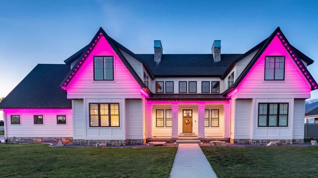 Pink and warm white roofline lighting on a two-story home